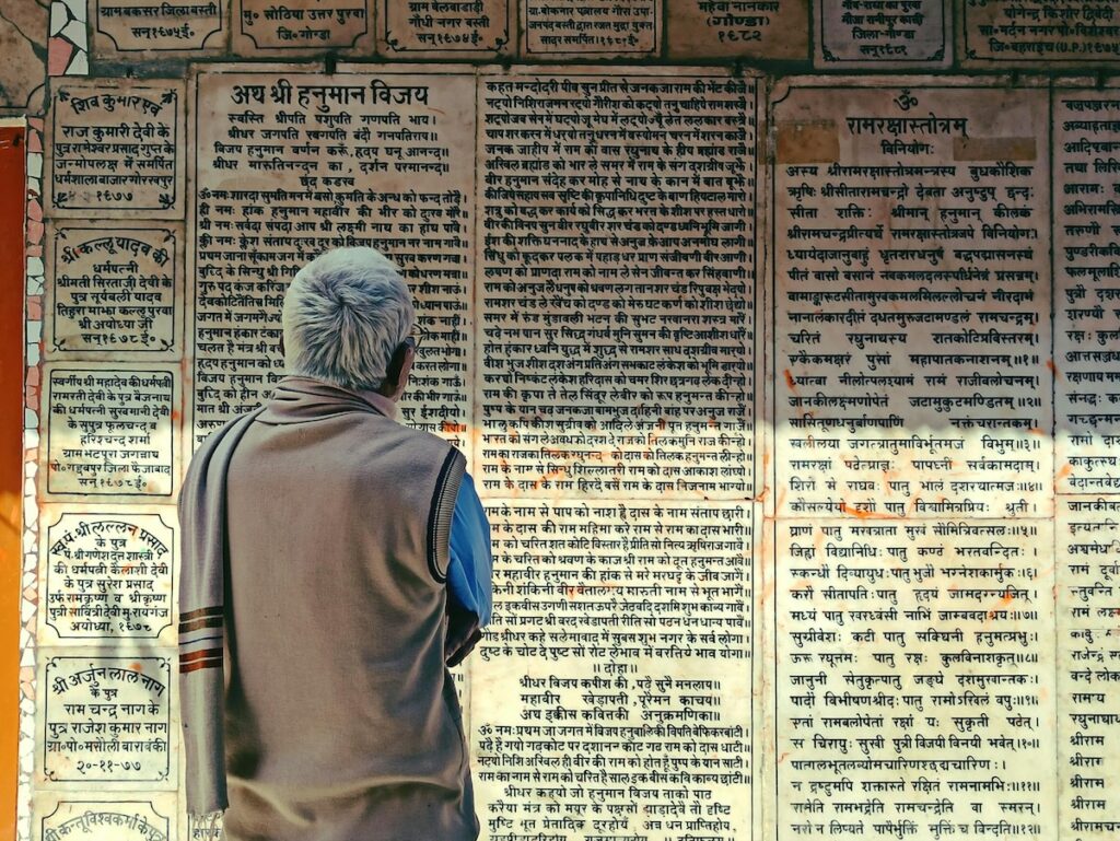 A man reading a wall of Sanskrit texts in India
