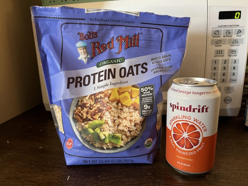 Travel snack setup with Bob’s Red Mill gluten-free protein oatmeal and a can of Spindrift seltzer.