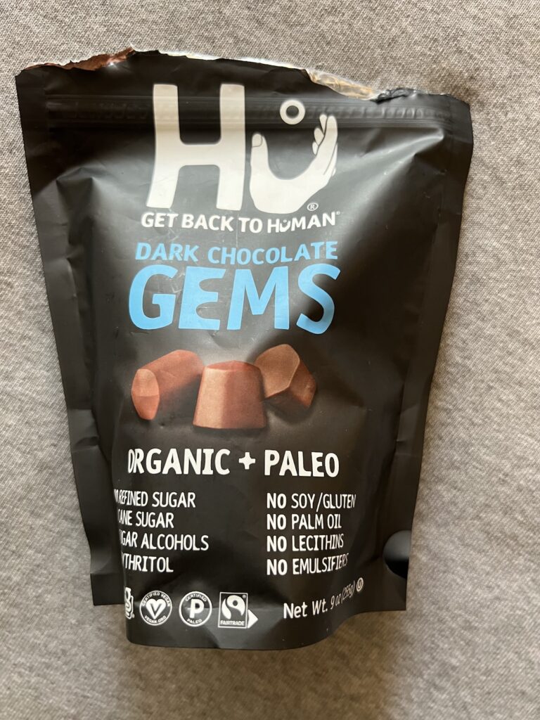 Bag of Hu dark chocolate snacking gems, a travel-friendly sweet snack option.