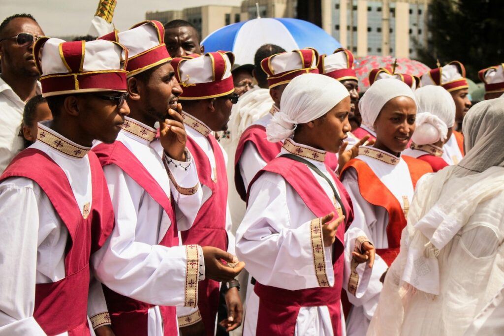 Young men and women dressed in ceremonial white and red robes during Timkat, the Ethiopian Epiphany celebration.