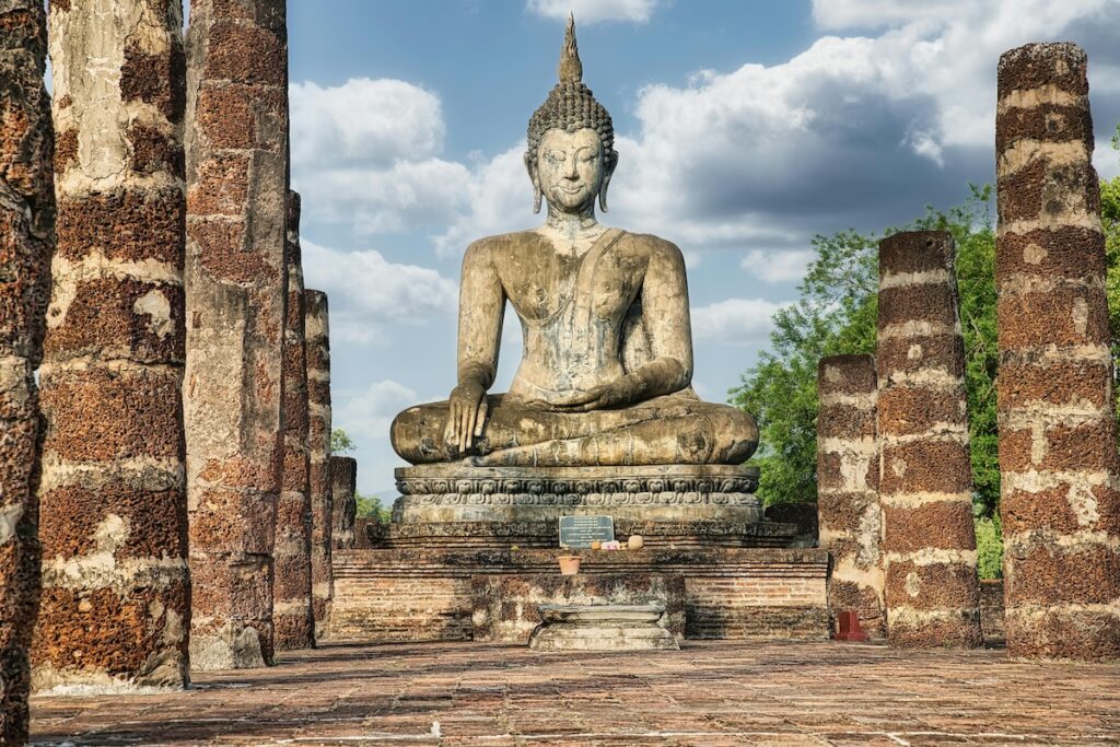 A Buddha Statue amongst Temple Ruins in Sukhothai, Thailand