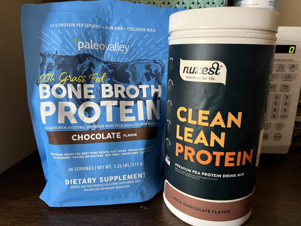 Chocolate Nuzest pea protein powder and Paleovalley bone broth protein powder side by side.